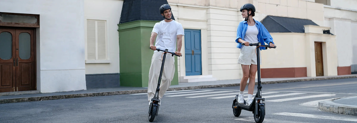 Twee mensen rijden door de stad op de Xiaomi Electric Scooter 6