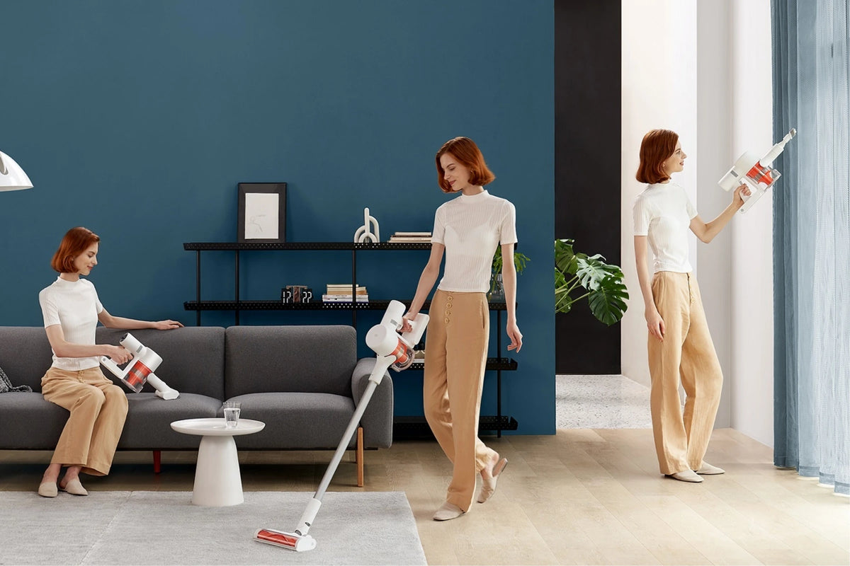 Vrouw gebruikt de Xiaomi steelstofzuiger als handstofzuiger op de bank, op de vloer en omhoog langs de muur